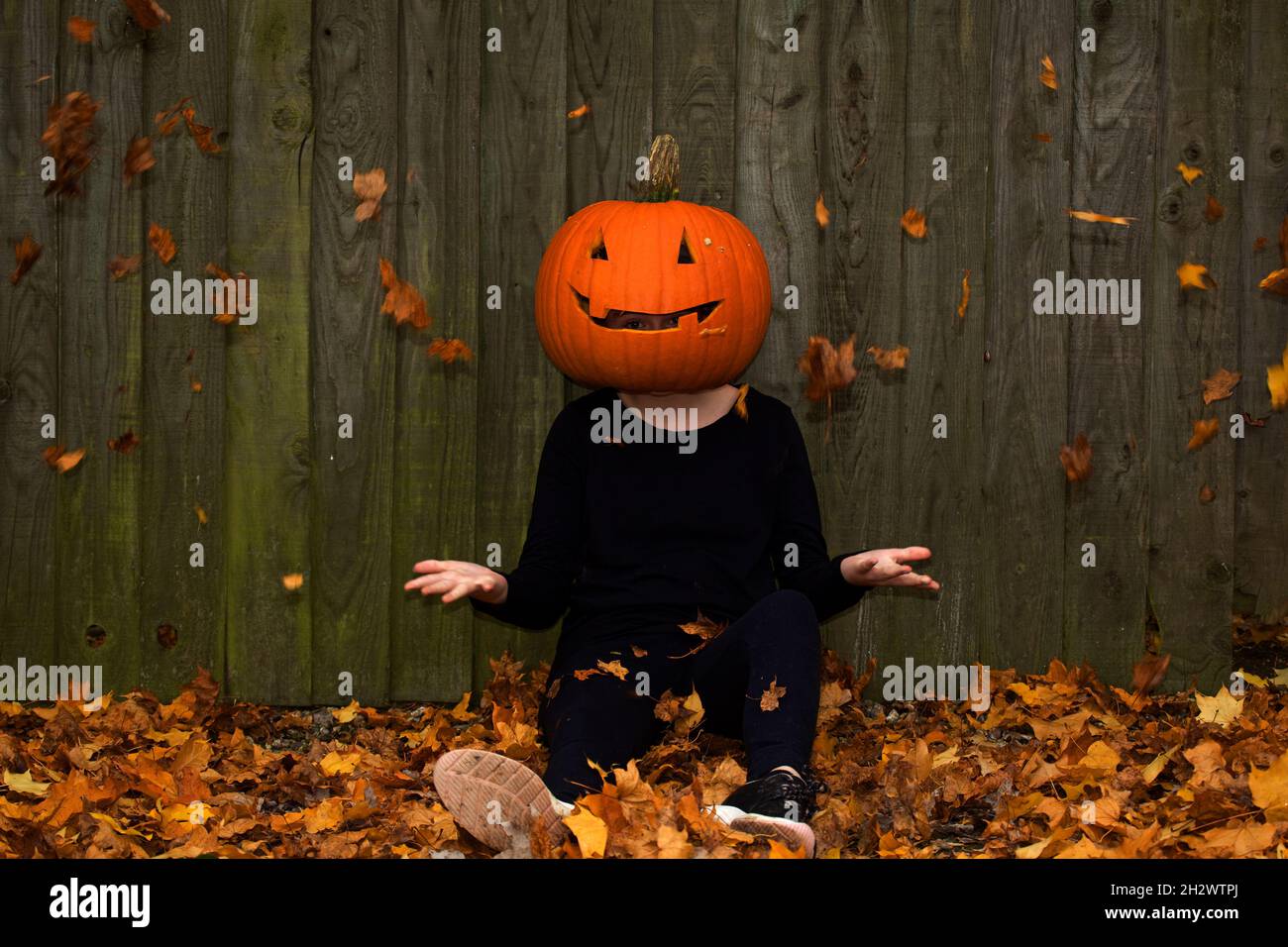 Young girl with carved pumpkin for a head Stock Photo