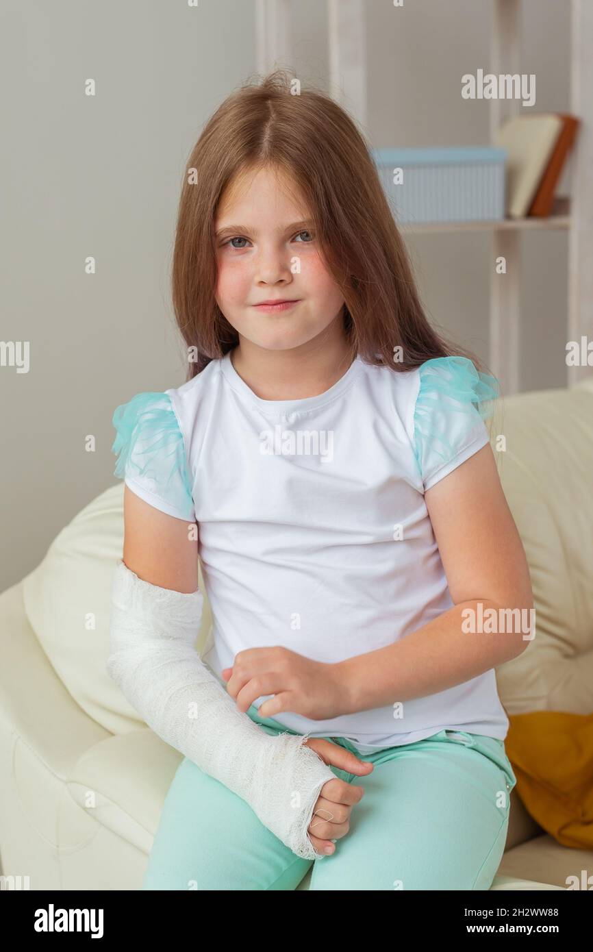 Child with a cast on a broken wrist or arm smiling and having fun on a