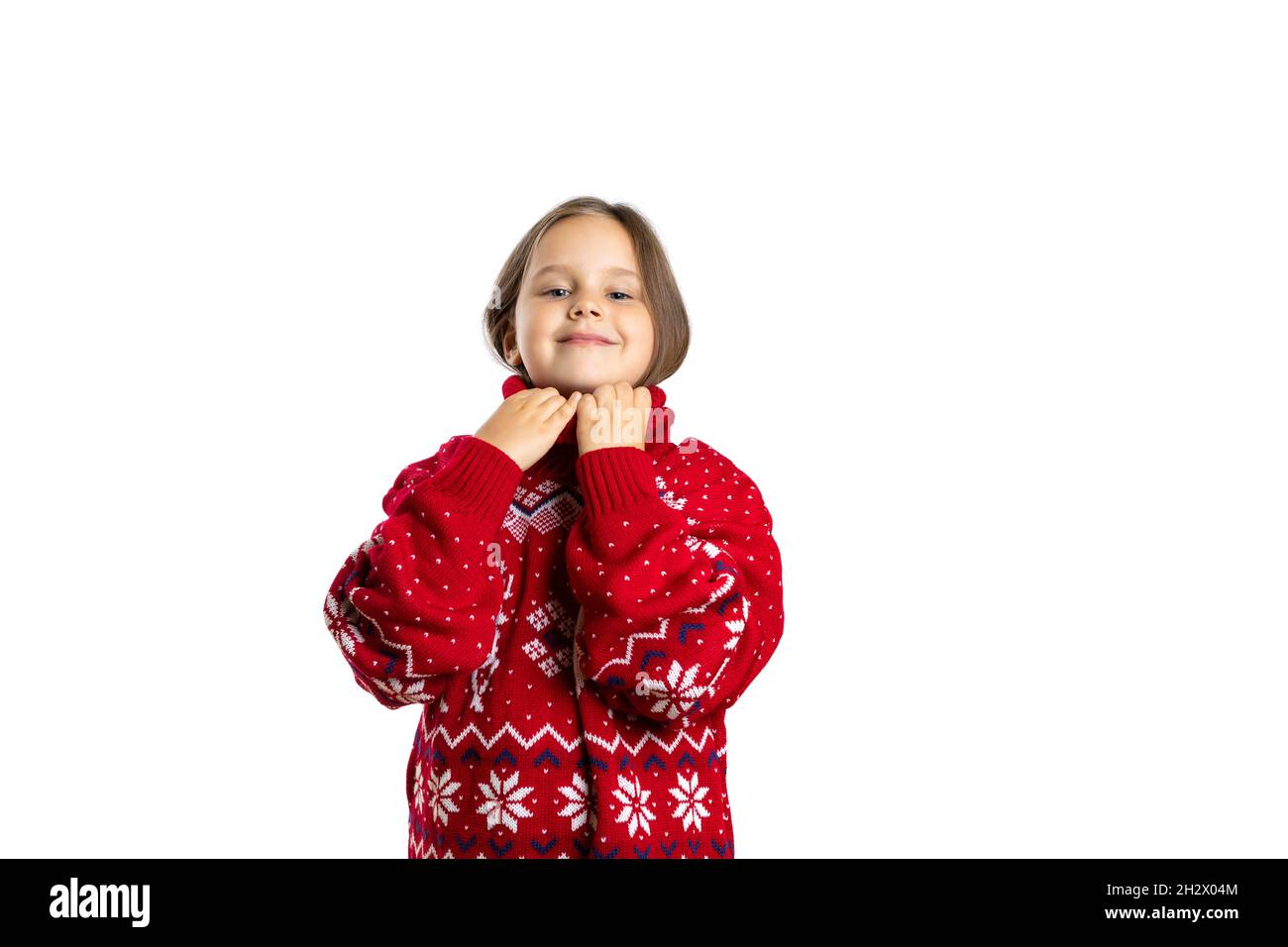 portrait of smiling, joyful girl in oversize red knitted Christmas sweater with reindeer getting ready and going to Christmas party, isolated on white Stock Photo