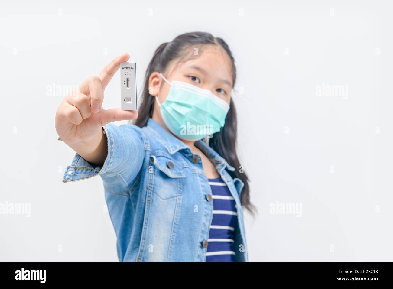 cute traveler wear mask shows rapid Coronavirus Covid-19 negative test device with negative test result isolated on white background, new normal trave Stock Photo