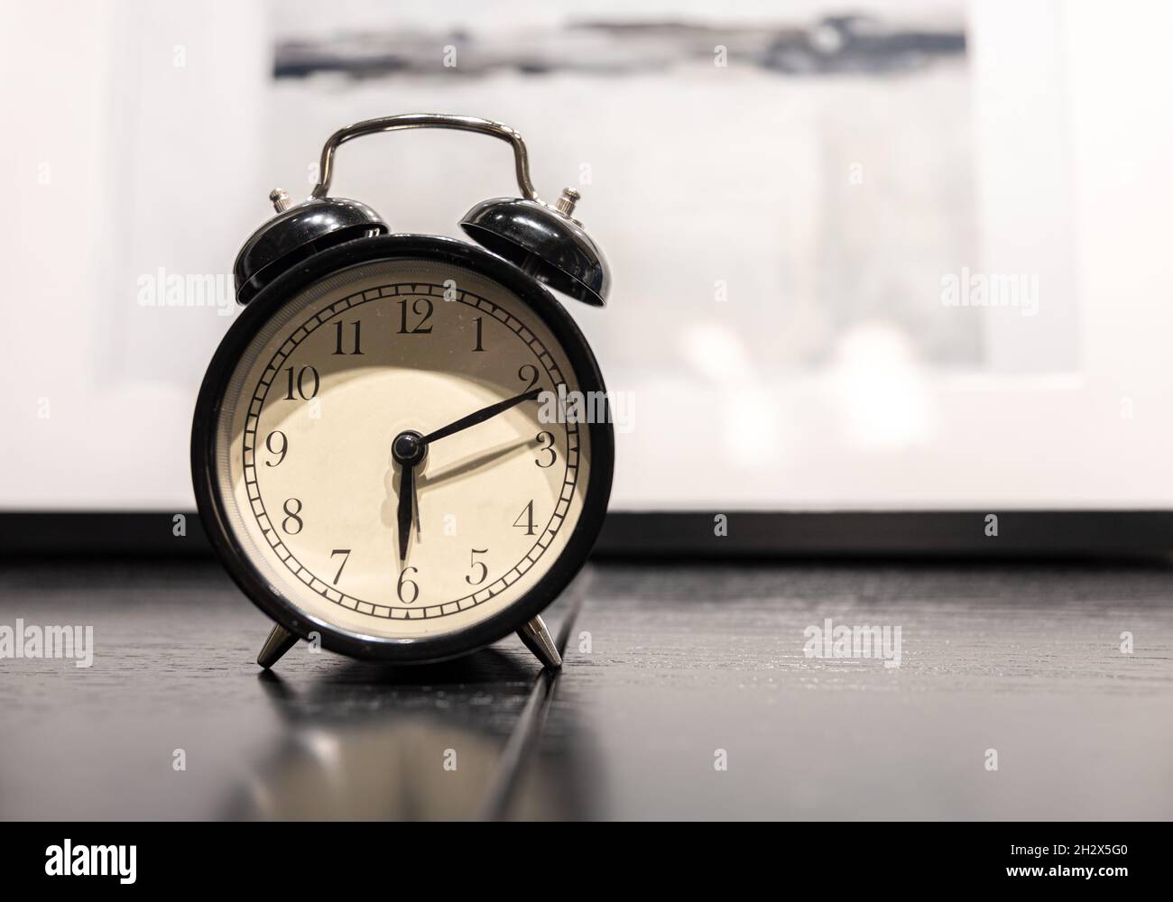 Close-up of a vintage alarm clock on a blurred background. Stock Photo