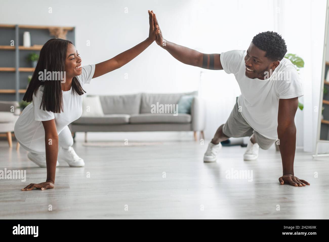 Young black couple planking and giving high five Stock Photo