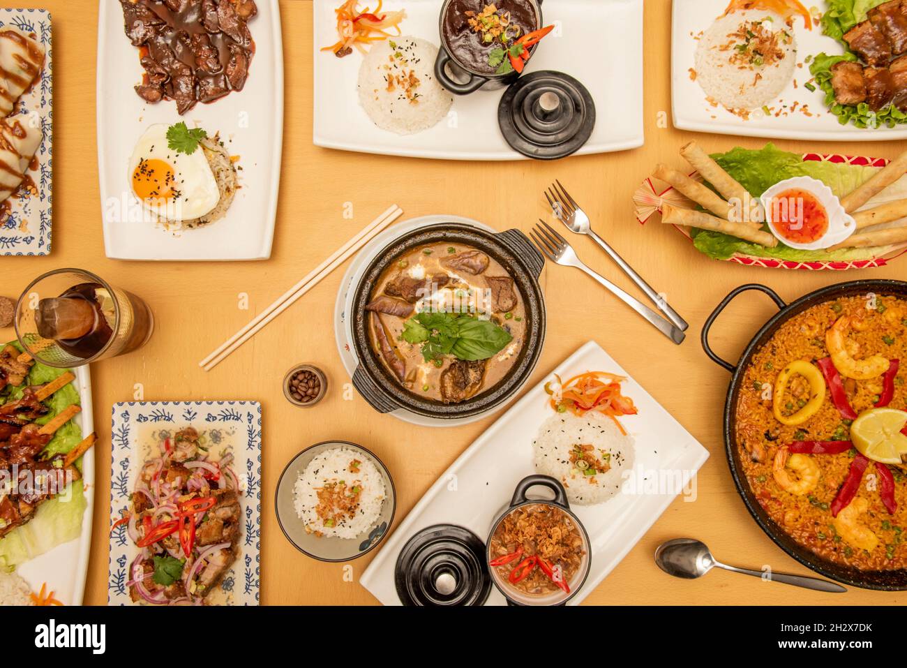 Top view image of Philippine food recipes and paella with pork stews and white rice, seafood and fried eggs Stock Photo