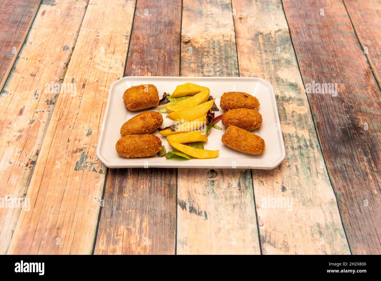 Serrano ham croquettes serving with homemade chips served as tapas in a