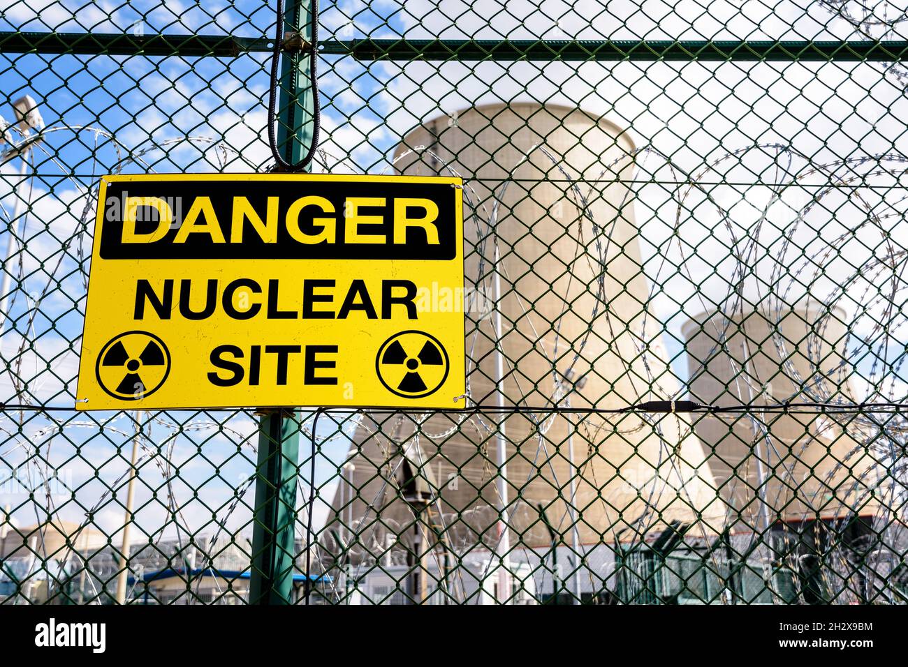 A yellow danger warning sign on the security fence of a nuclear power