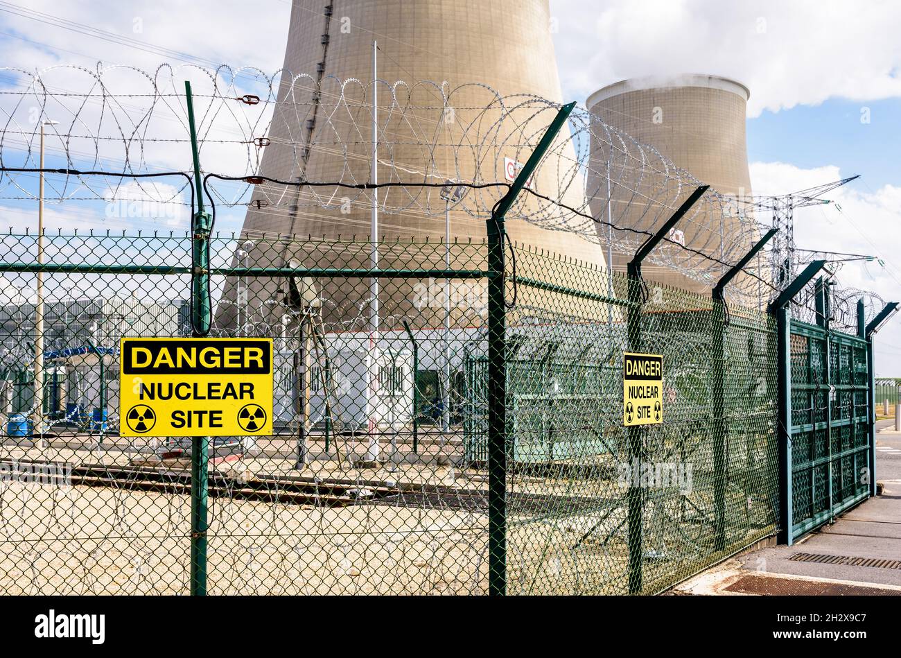 Security fence of a nuclear power station with yellow danger warning
