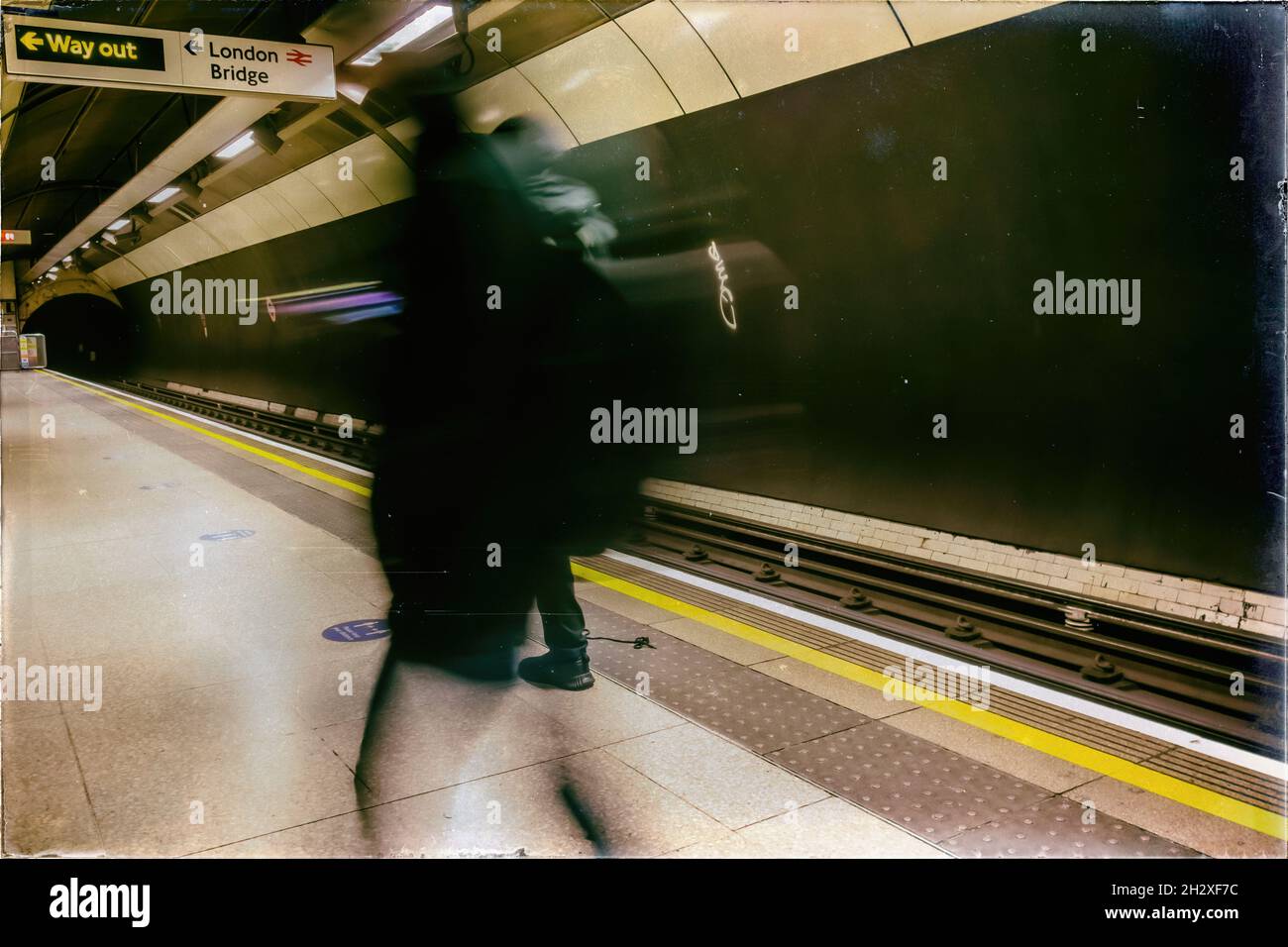 Soft blurred image of passengers walking on a tube station platform at London Bridge underground tube station, taken on the 12th of December 2020 Stock Photo