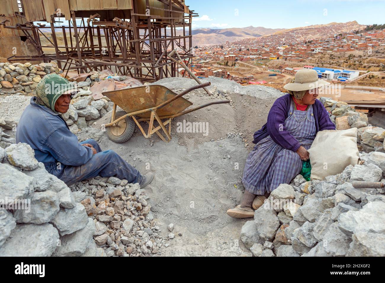 A couple of bolivian indigenous silver miners chewing coca leaves during a break on the Cerro Rico Potosi mountain, Potosi, Bolivia. Stock Photo