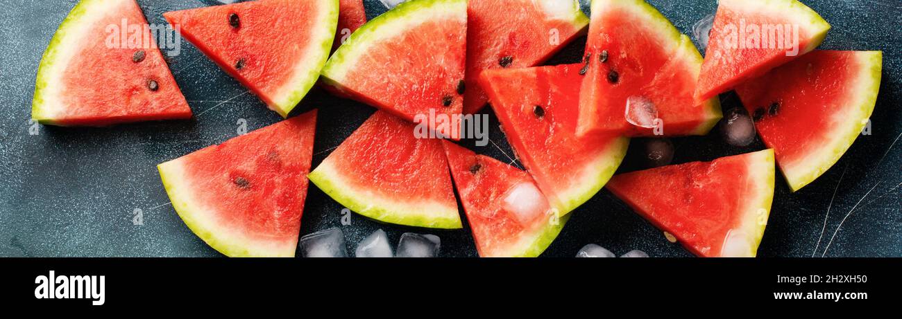 Slices of fresh watermelon with ice on a blue concrete background ...