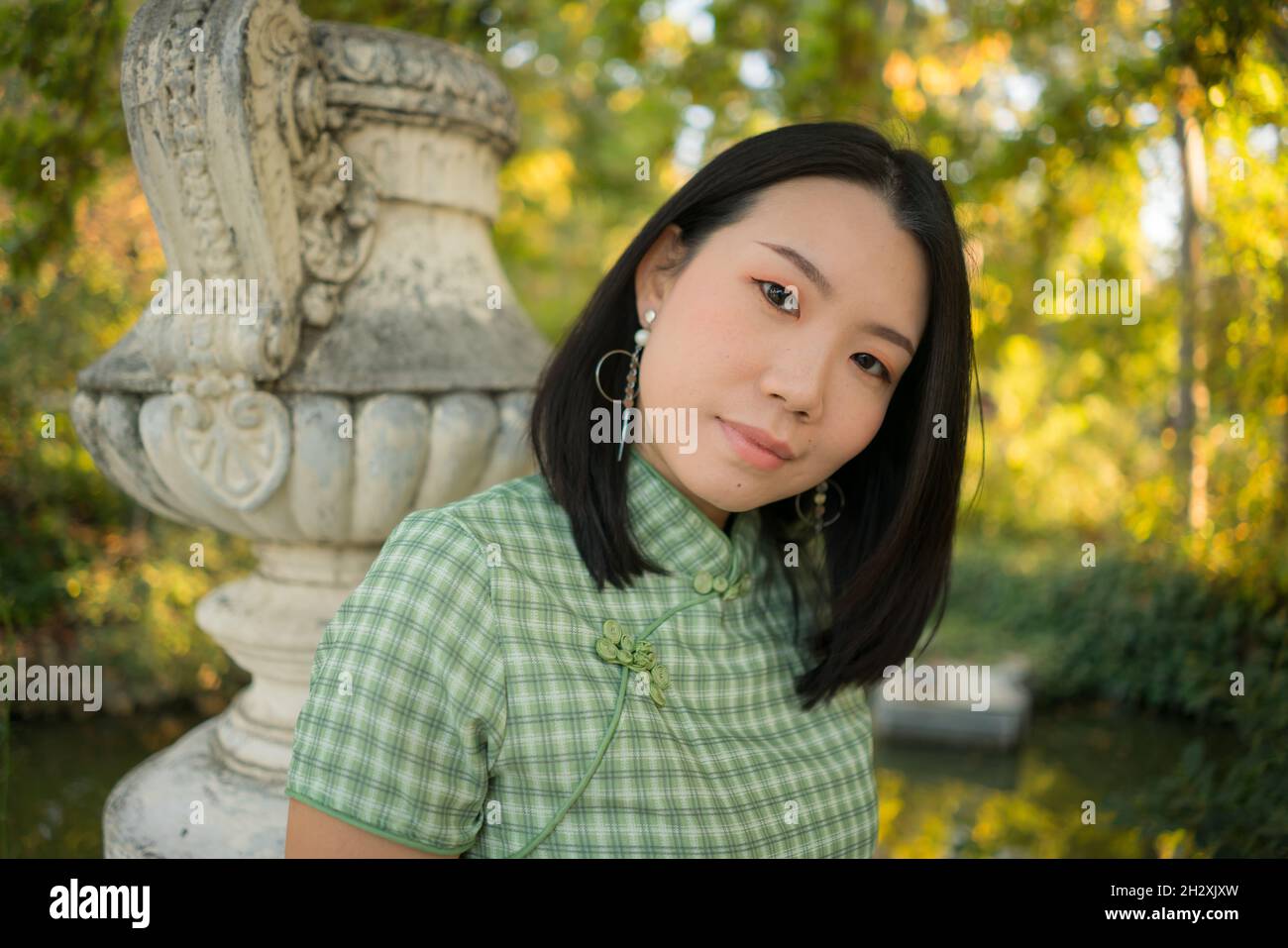 lifestyle portrait of young happy and attractive Asian Chinese woman relaxed taking a walk on city park enjoying Autumn nature during weekend getaway Stock Photo