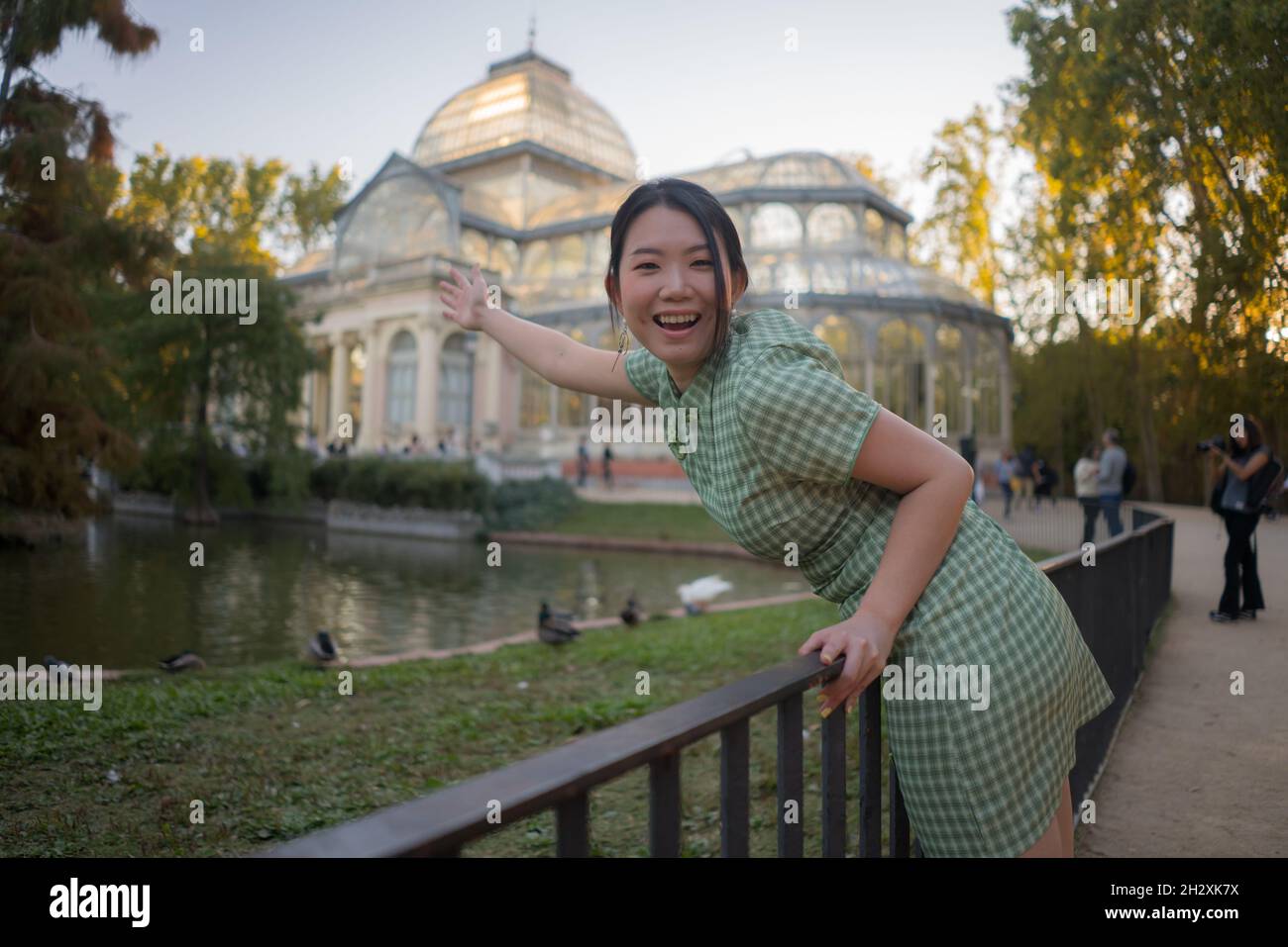 lifestyle portrait of young happy and attractive Asian Chinese woman relaxed taking a walk on city park enjoying travel getaway in Spain during Autumn Stock Photo
