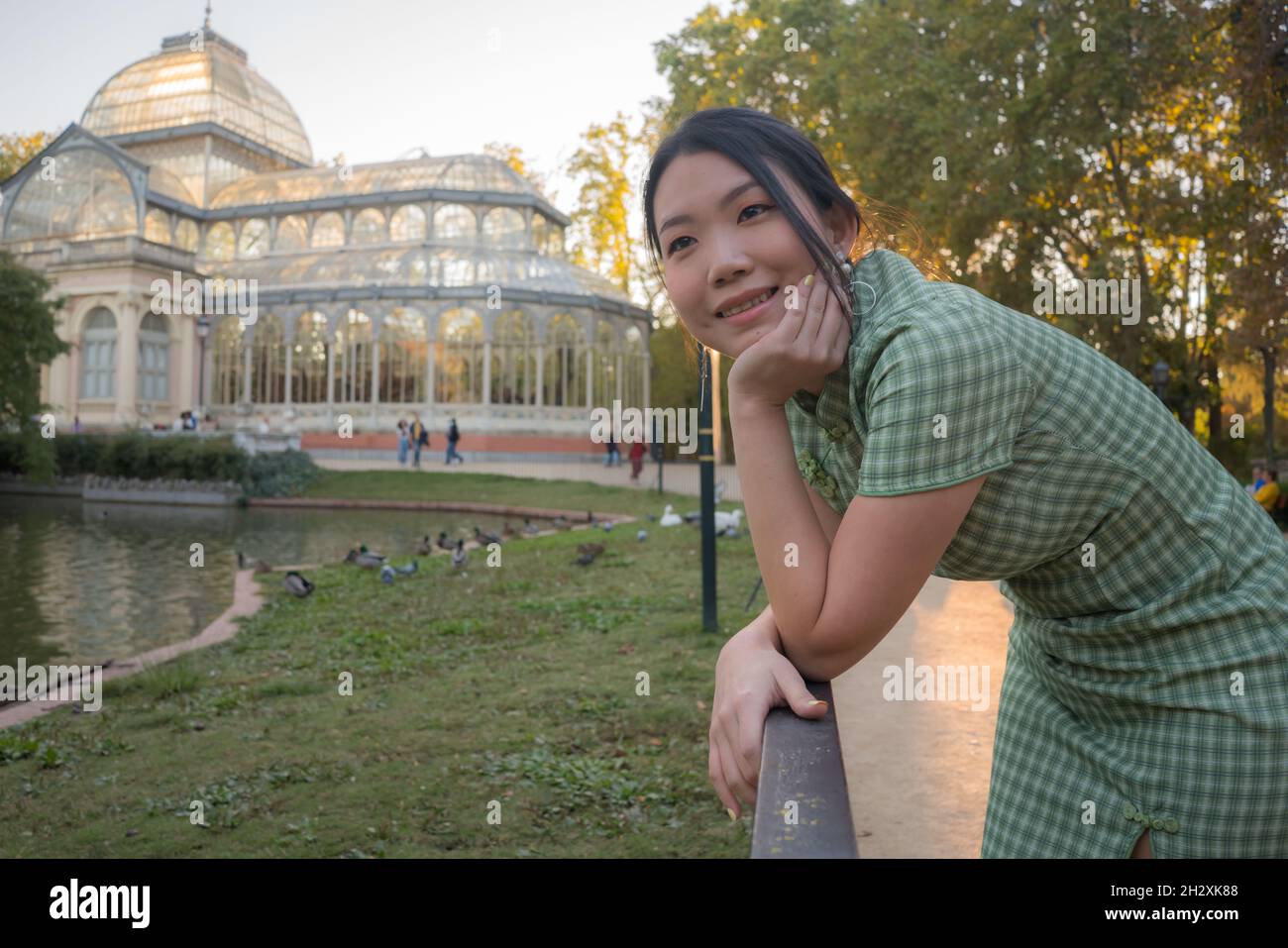 lifestyle portrait of young happy and attractive Asian Chinese woman relaxed taking a walk on city park enjoying travel getaway in Spain during Autumn Stock Photo