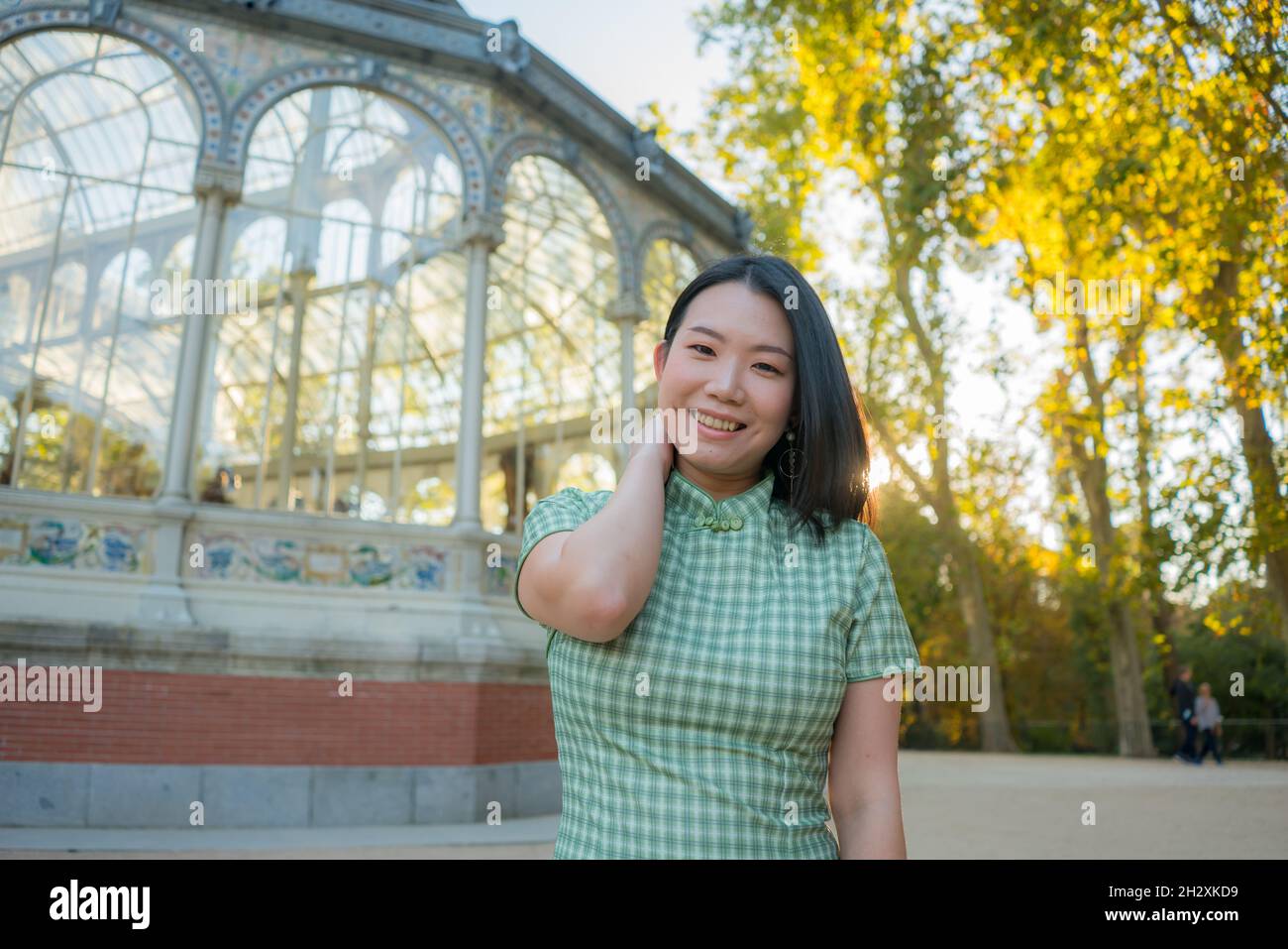 lifestyle portrait of young happy and attractive Asian Japanese woman relaxed taking a walk on city park enjoying travel getaway in Spain during Autum Stock Photo