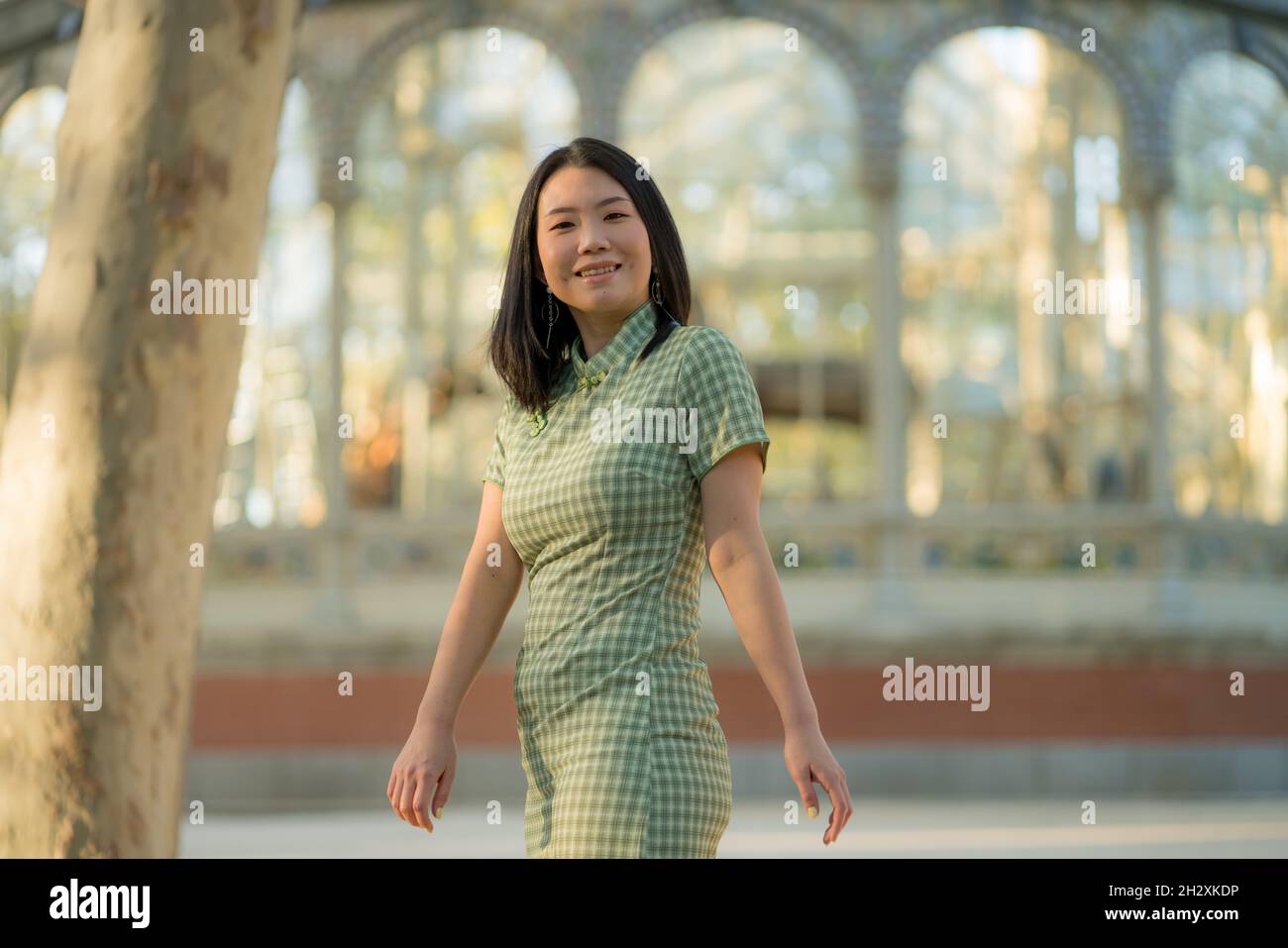 lifestyle portrait of young happy and attractive Asian Japanese woman relaxed taking a walk on city park enjoying travel getaway in Spain during Autum Stock Photo