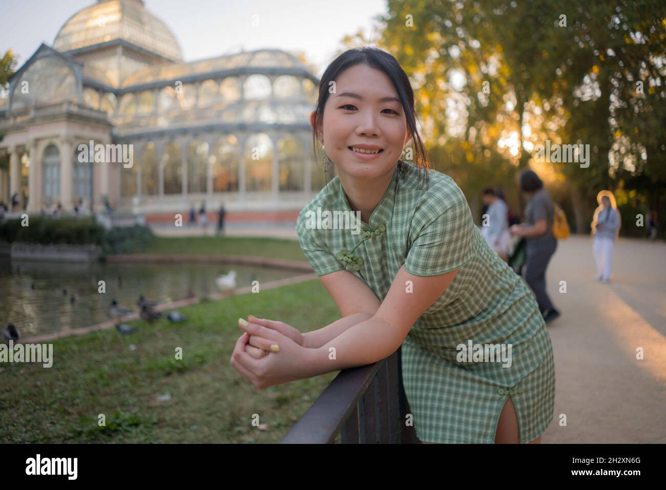 lifestyle portrait of young happy and attractive Asian Korean woman relaxed taking a walk on city park enjoying travel getaway in Spain during Autumn Stock Photo