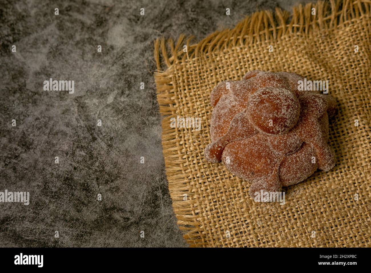 Sweet bread called Bread of the Dead (Pan de Muerto) on the brown sacking Stock Photo