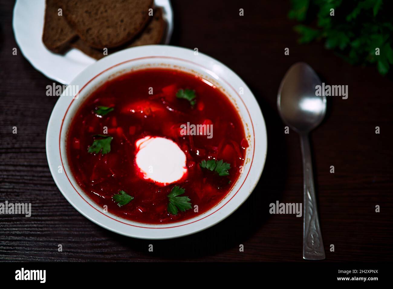 A top view of a plate of red Russian borsch on a dark surface. Stock Photo