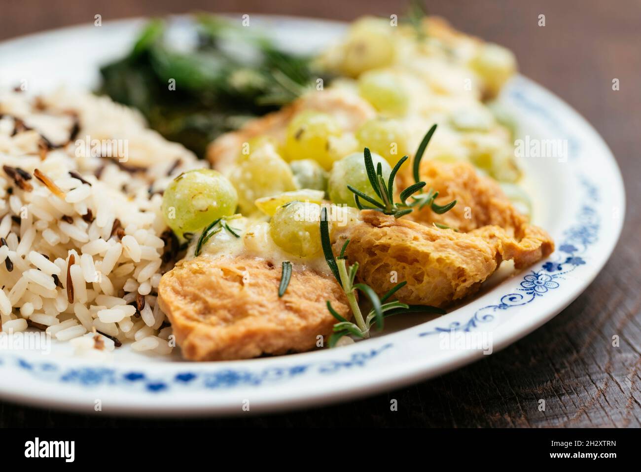 Plate with rice and soy medallions with a creamy grape sauce. Stock Photo