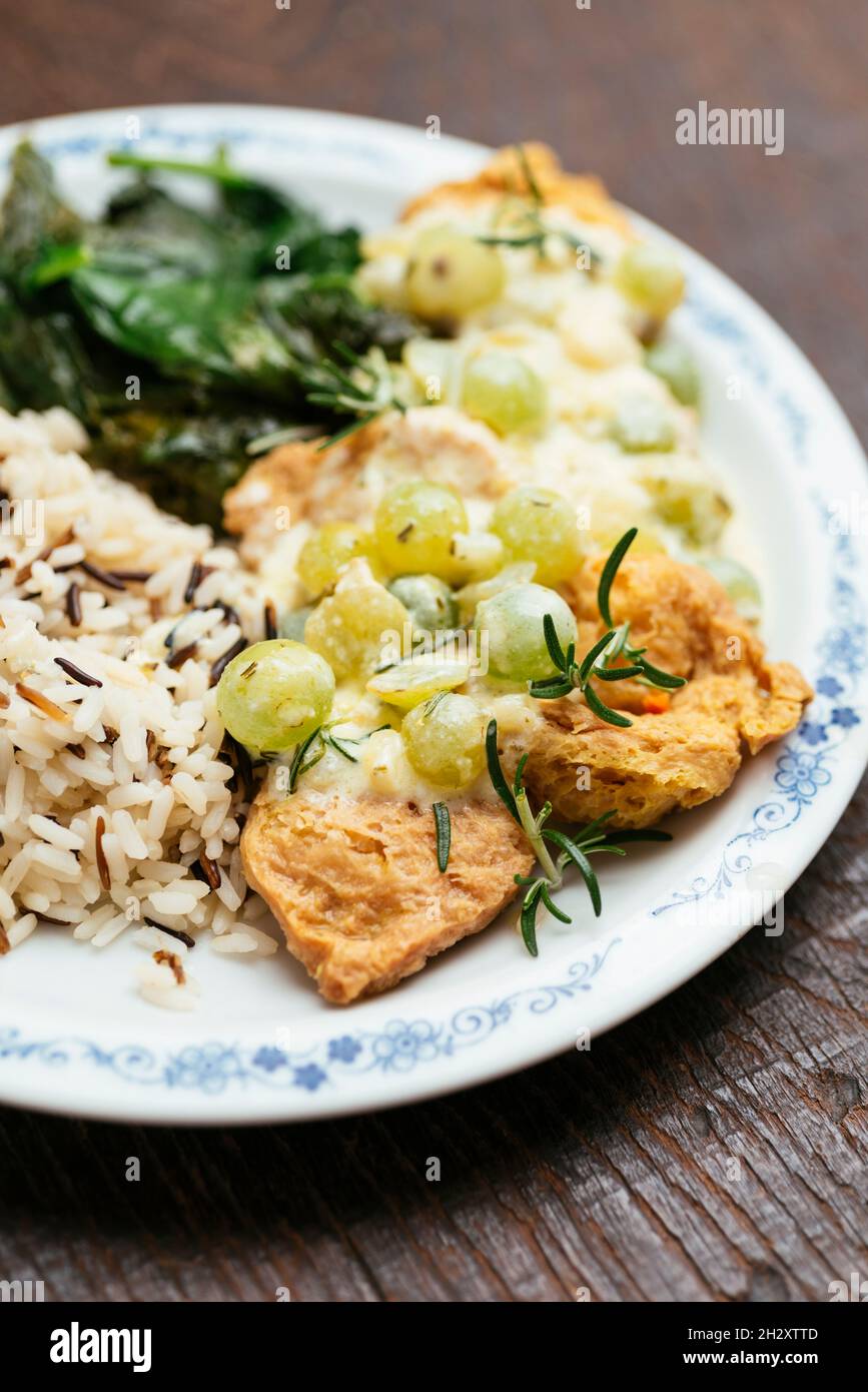 Plate with rice and soy medallions with a creamy grape sauce. Stock Photo