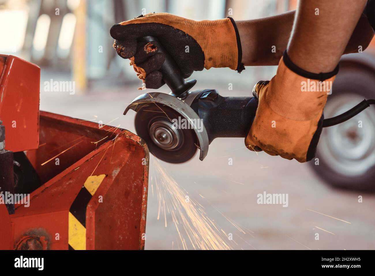 Technician with disk grinder working on farm machine Stock Photo Alamy