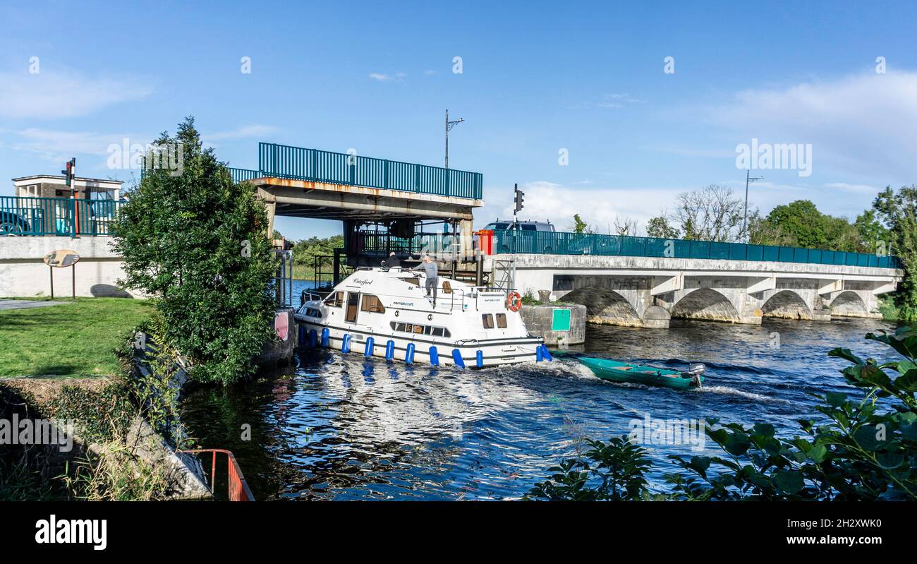 A canal cruiser navigating the River Shannon through the bridge lift at Tarmonbarry, County Roscommon, Ireland. Stock Photo
