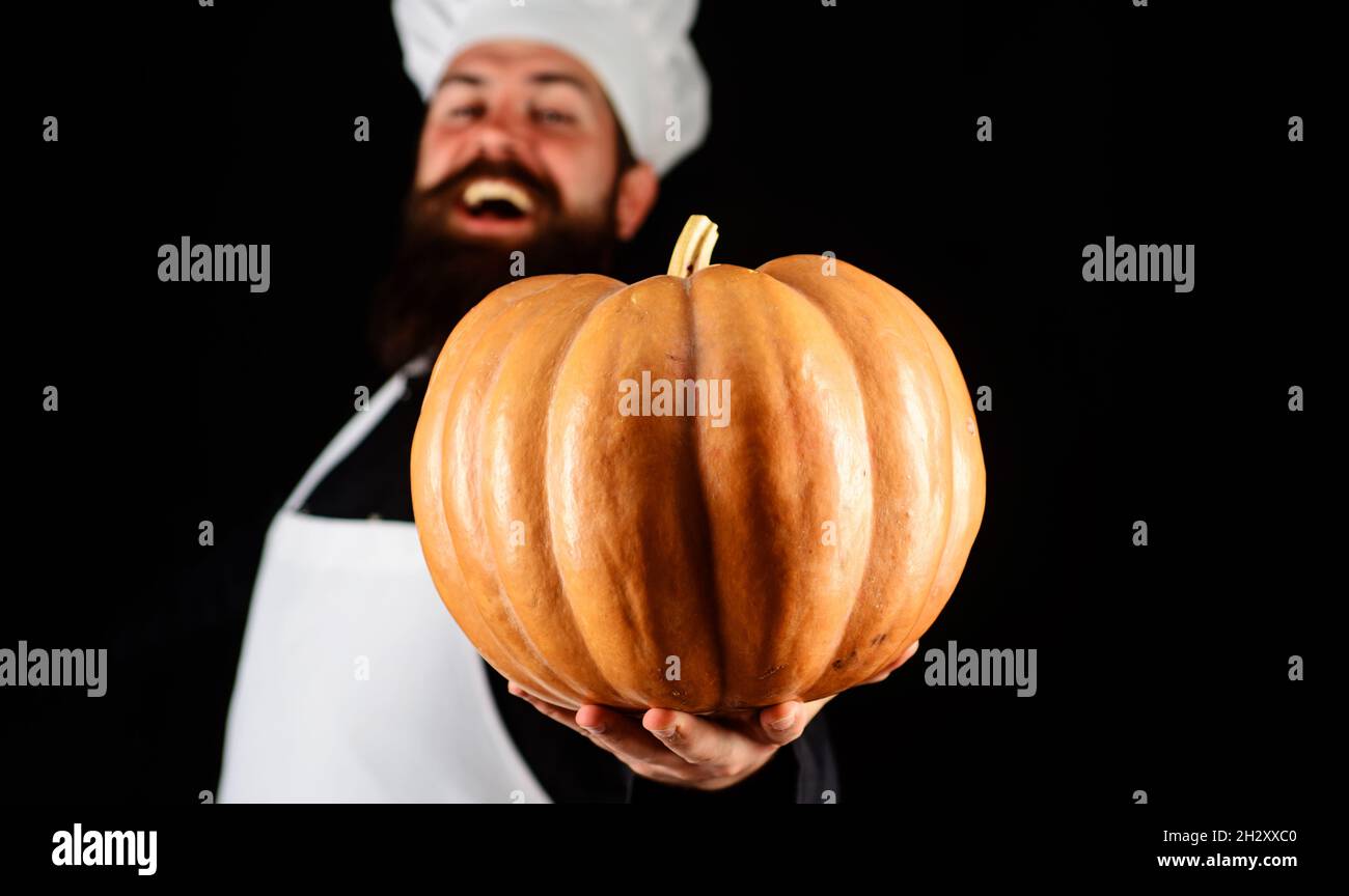 Happy Chef with pumpkin. Seasonal vitamin. Halloween. Thanksgiving day cooking. Selective focus on pumpkin Stock Photo