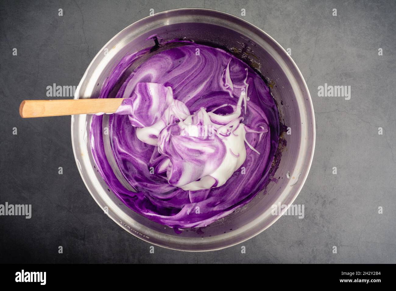 Mixing Meringue into Ube Cake Batter Using a spatula to mix up cake batter made with purple