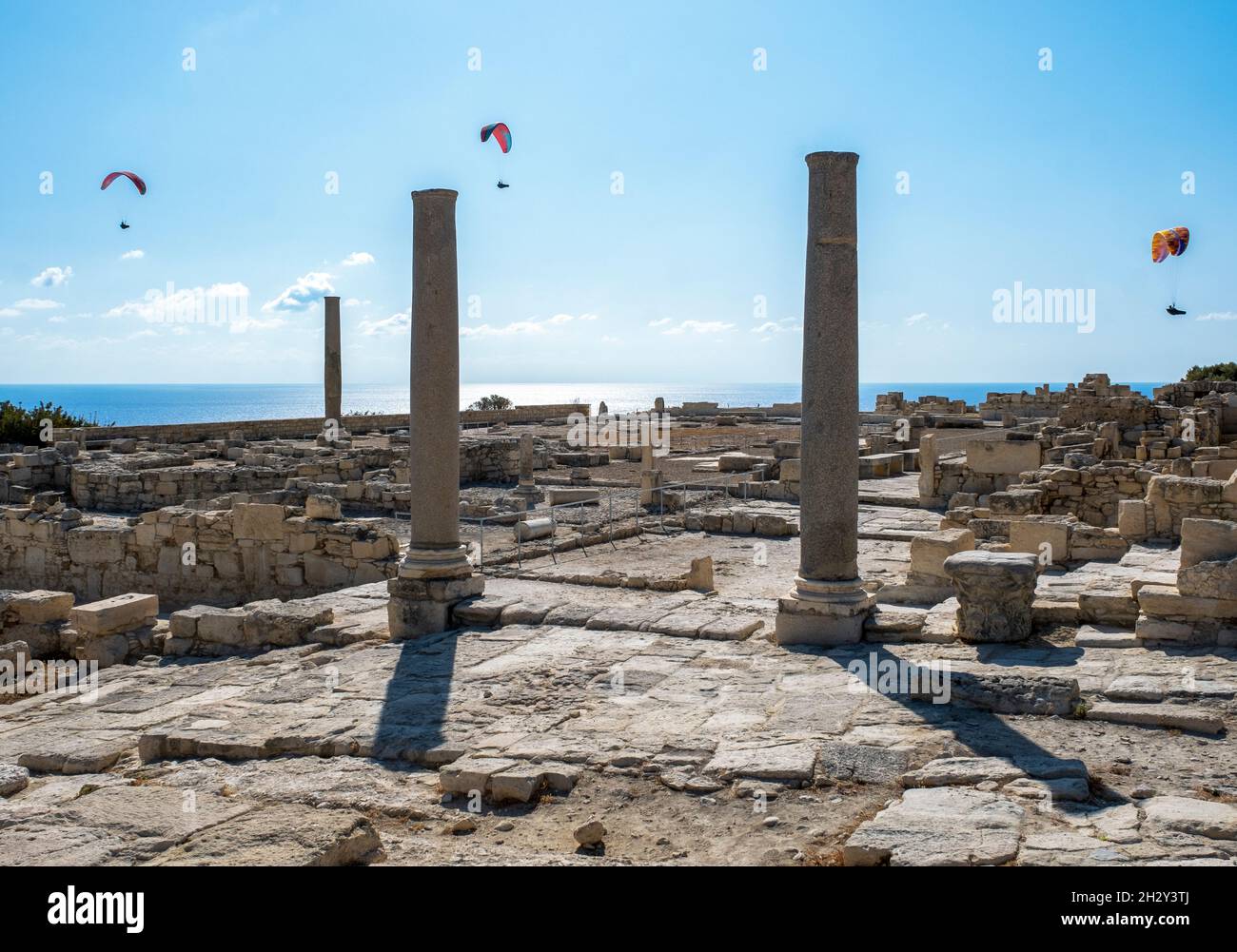 Paragliders glide over the early Christian Basilica ruins at the Archaeological Site of Kourion, Cyprus. Stock Photo