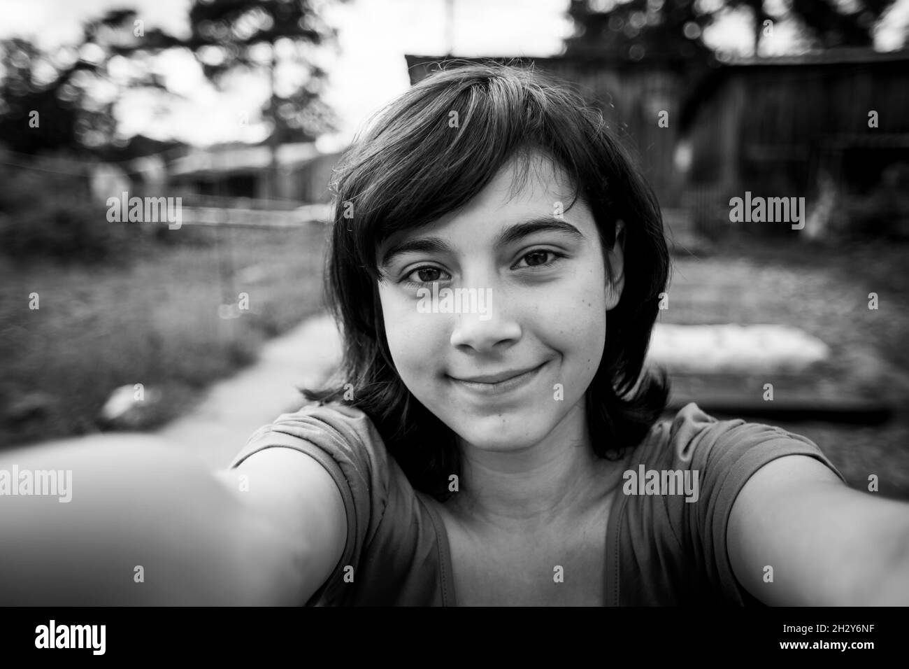 Teenage girl takes a selfie in the village. Black and white photo. Stock Photo
