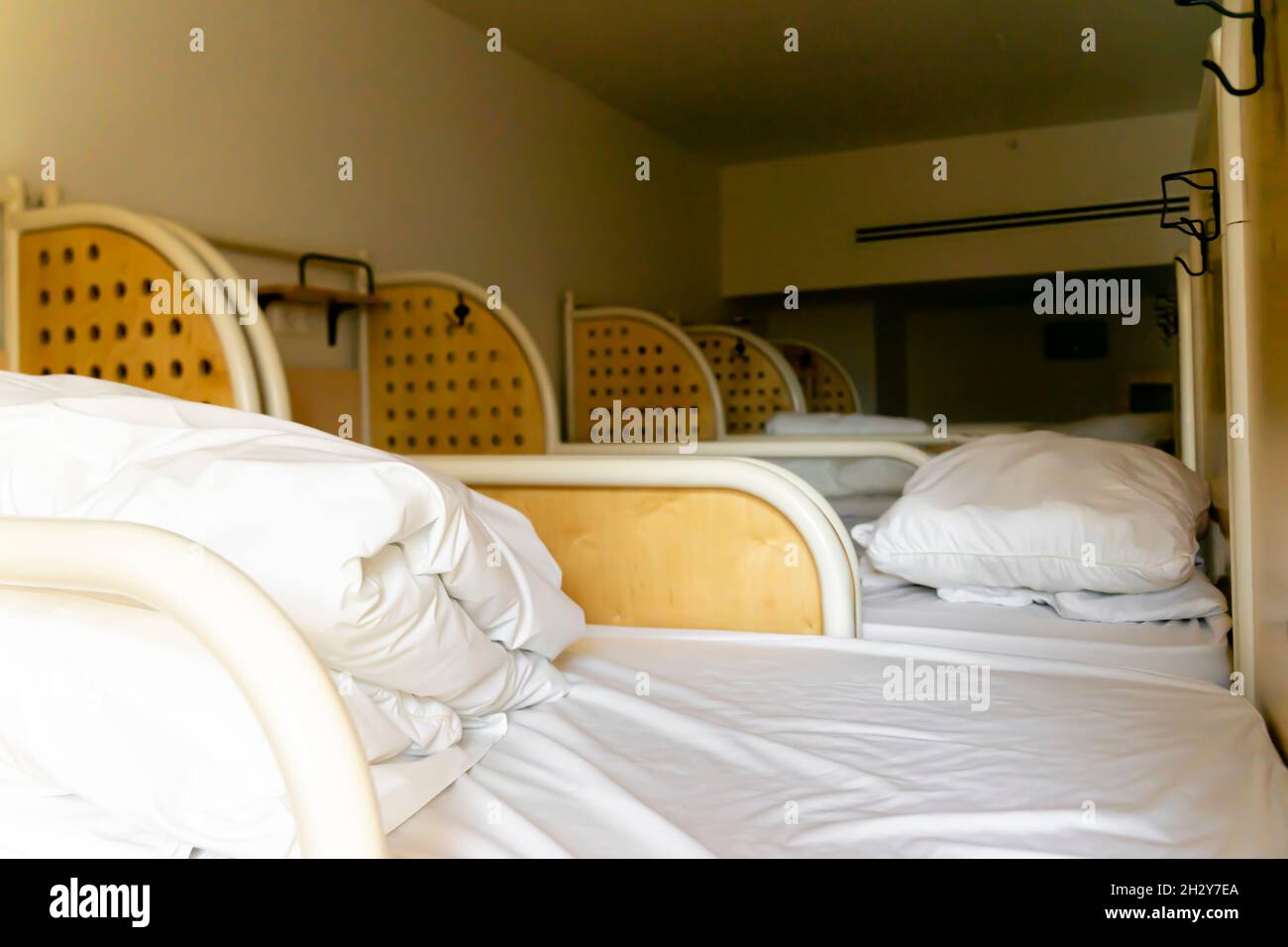 Upper berthes of bunkbeds with freshly made beds in 8person occupancy