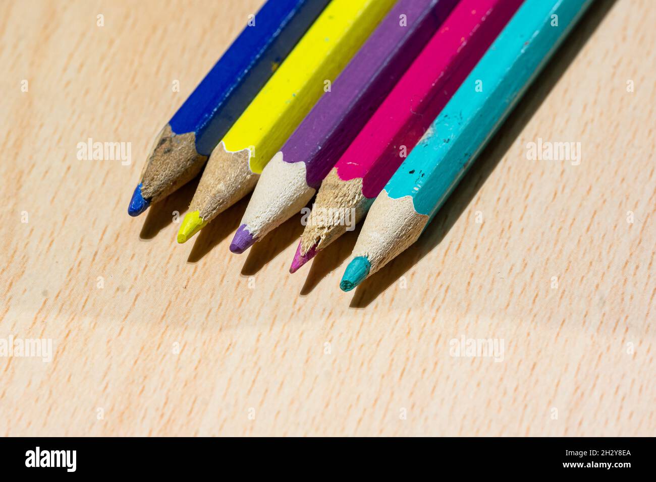 Colouring pencils lined up on a desk Stock Photo
