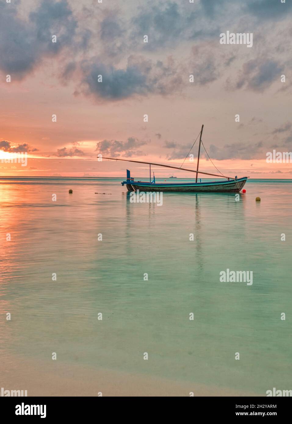 A vertical shot of a boat sailing in the sea at sunset Stock Photo - Alamy