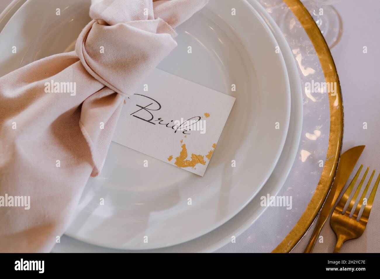 Wedding table setting. Gold plate for the bride close-up. Stock Photo