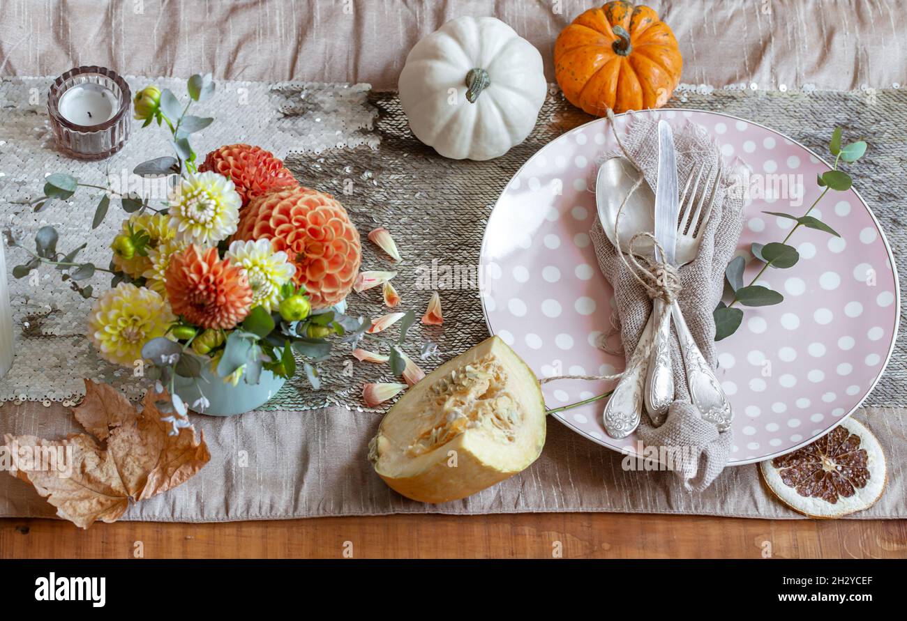 Festive table setting with pumpkins, candles and chrysanthemum flowers ...