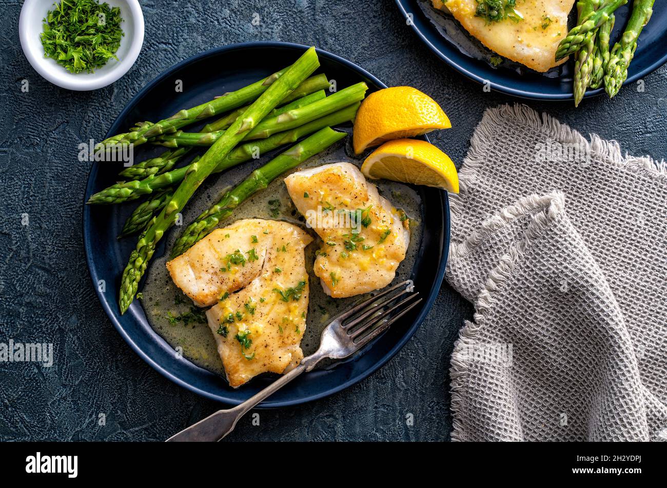Delicious pan seared halibut with lemon butter sauce and asparagus. Stock Photo