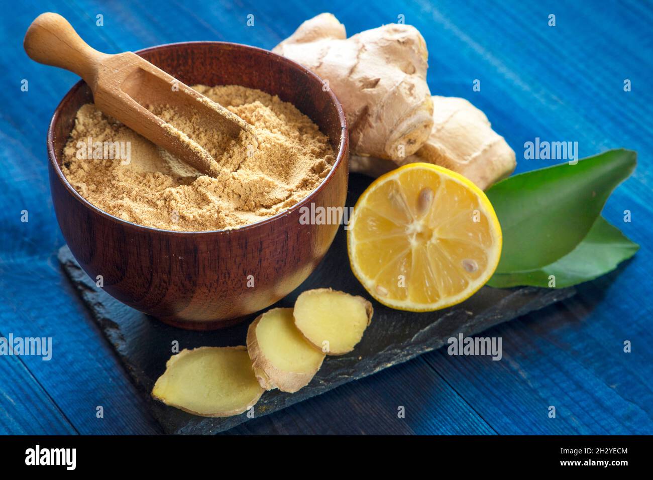ginger root and powder on black stone plate Stock Photo