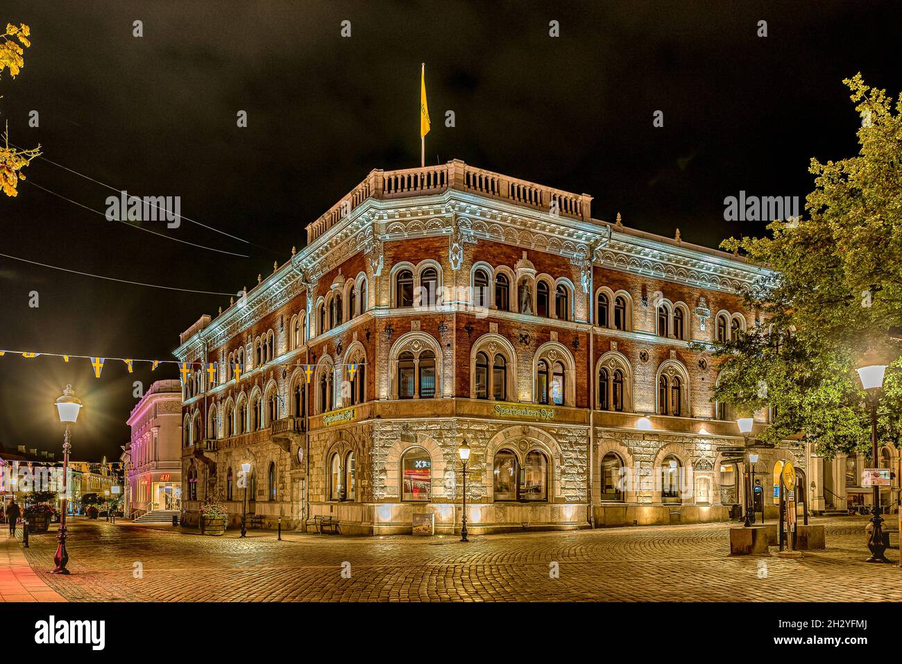 a streetlight shining at the illuminated headquarters of the Savings Bank South in Ystad, Sweden, September 14, 2021 Stock Photo