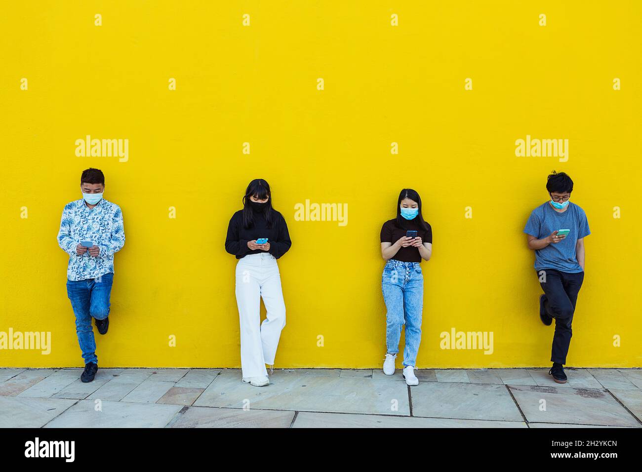 Group of asian people wearing face mask using smartphone Stock Photo