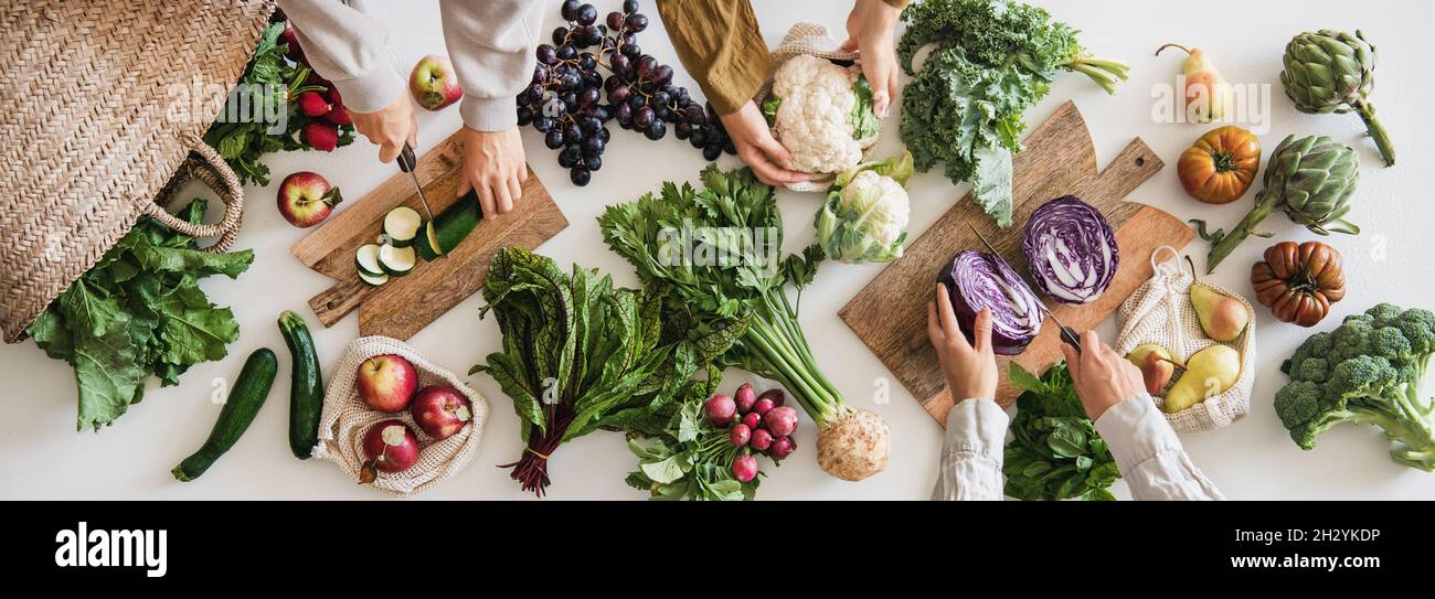 Female hands cutting various veggies and fruits, top view Stock Photo