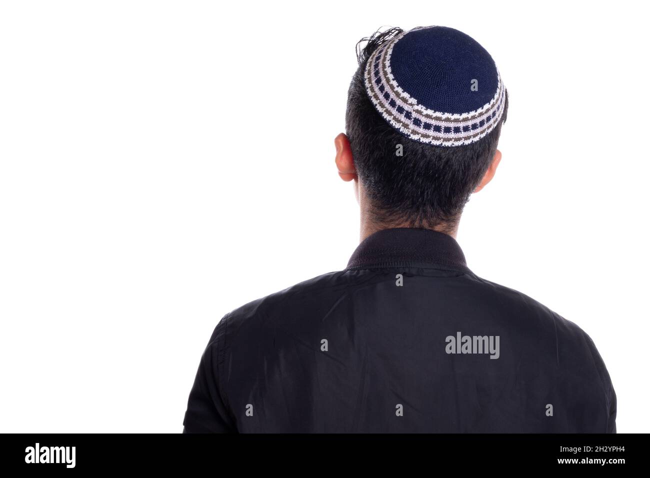 Man wearing kipa seen from the back, white background. religious person seen from behind. Stock Photo