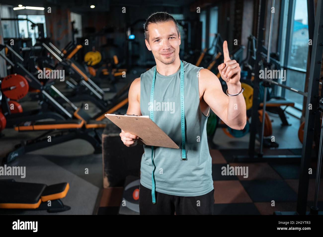 young attractive man personal trainer planning workout with clipboard