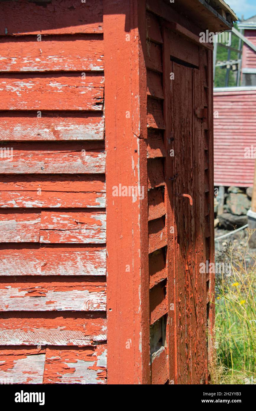 A close up of the exterior corner view of a bright red wooden textured