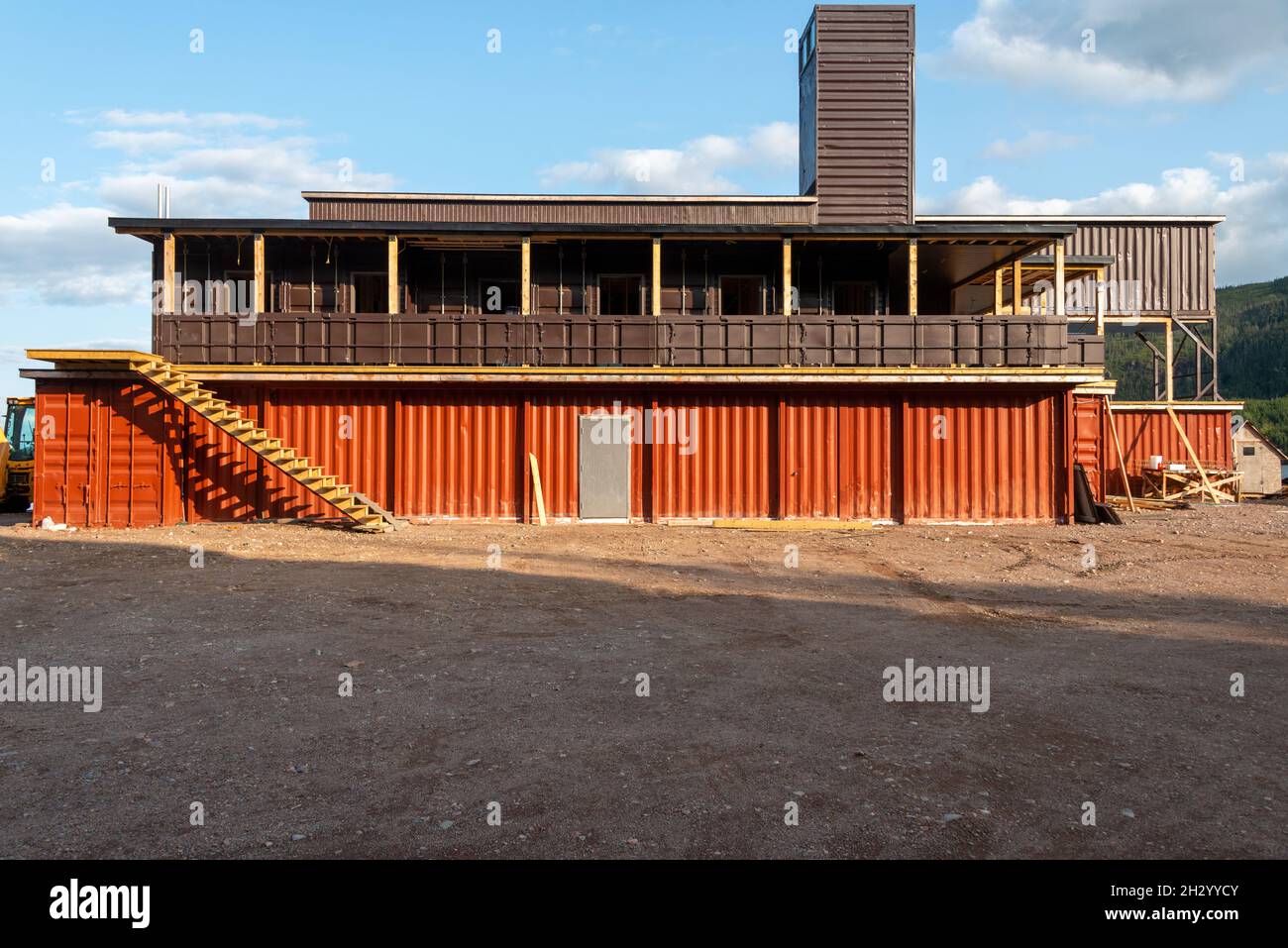 Newfoundland, Canada-October 2021: The exterior construction of a hotel using shipping containers as modular construction. Recycled brown and orange m Stock Photo