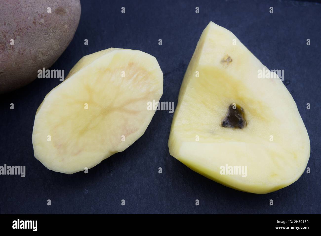 Split potatoes with light and dark stripes inside, a symptom of the bacterial disease Candidatus Liberibacter solanacearum, transmitted by the psyllid Stock Photo