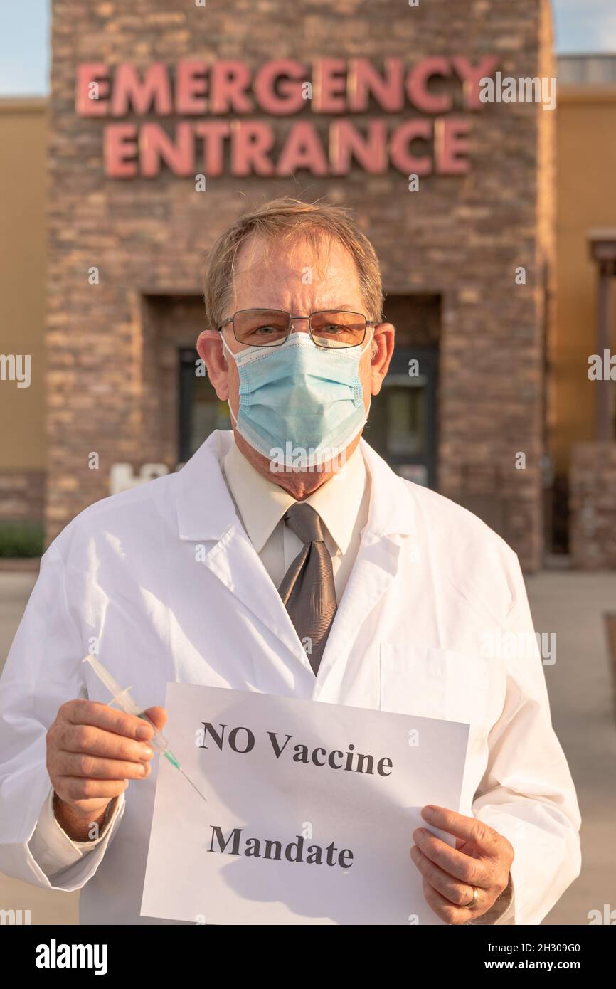 Anti-Vaxxer protestor holding sign in front of hospital Stock Photo
