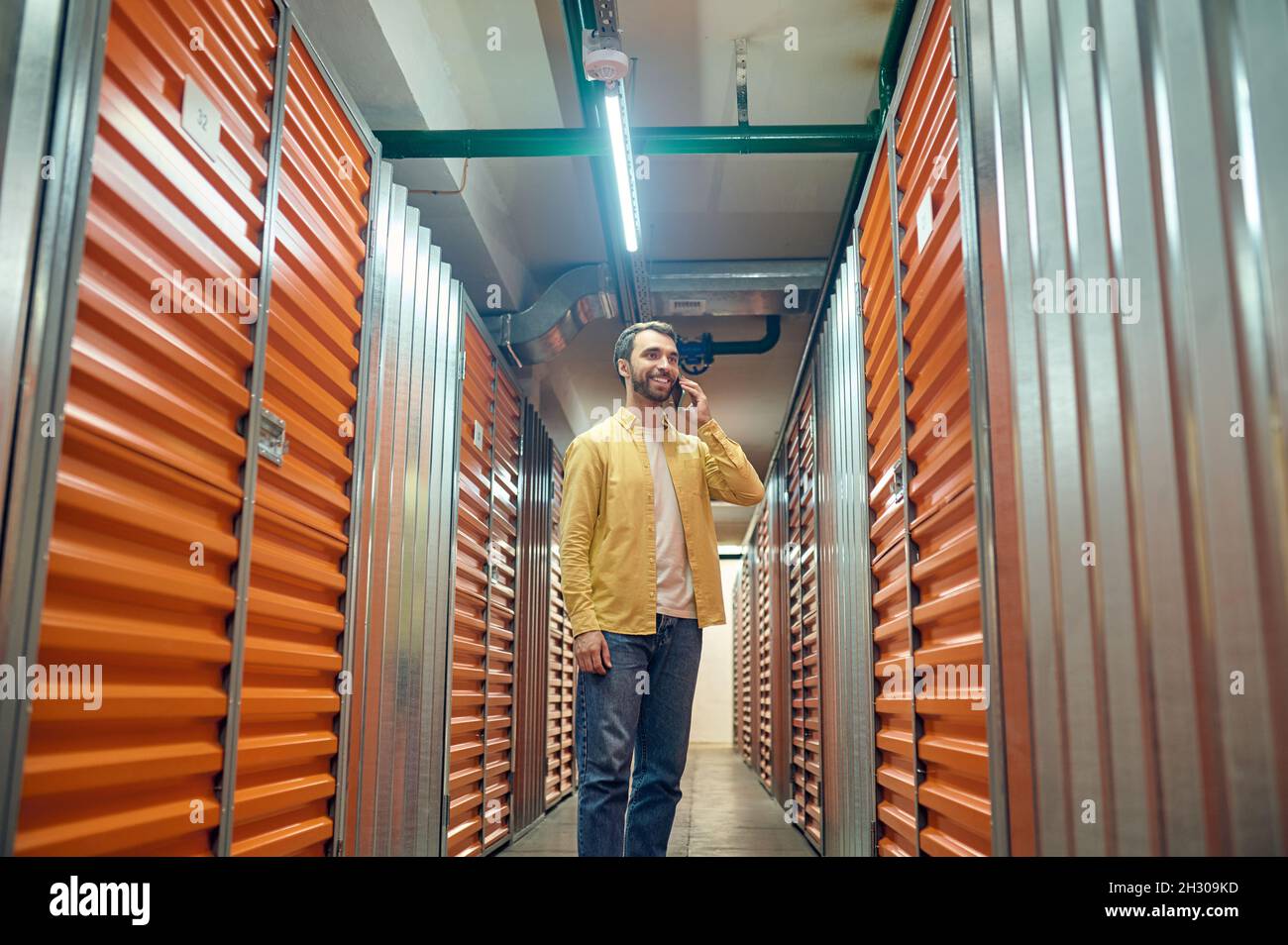 Man talking on smartphone in basement Stock Photo