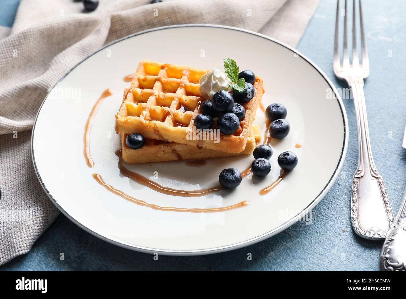 Plate of tasty Belgian Waffles with blueberry on table Stock Photo - Alamy