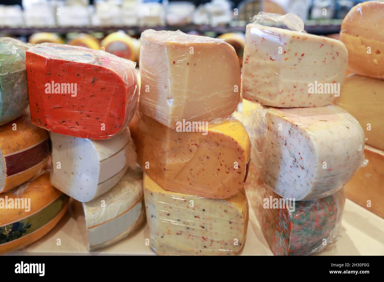 Several types of hard cheeses are for sale in a deli. Stock Photo