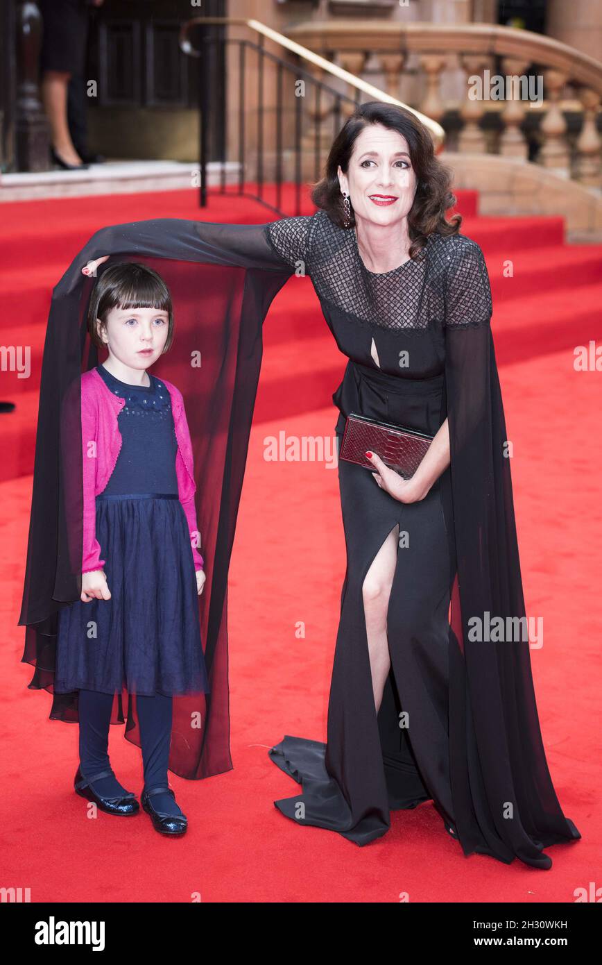 Raquel Cassidy shields Fifi Hart from the rain whilst arriving at the