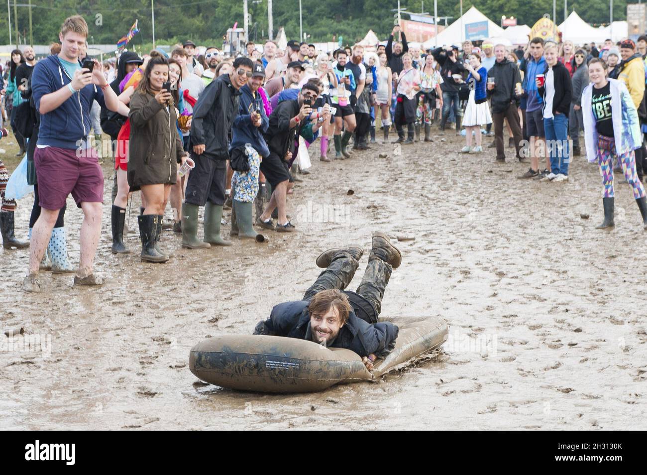 Festival goer slides through the mud on an airbed on day 3 of Bestival 2016, Robin Hill Country Park on the Isle of Wight.Picture Date: Saturday 10th September 2016.  Photo credit should read:  David Jensen/EMPICS Entertainment Stock Photo